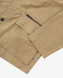 Close up view of Uskees khaki ripstop utility jacket with focus on a hip pockets, zip pocket and reinforced elbows.