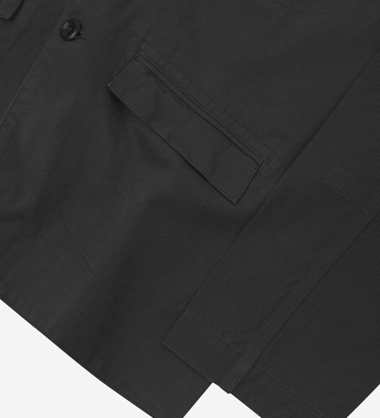 Close-up view of the cuff, jetted hip pocket and corozo buttons of the 3047 docklands blazer from Uskees. Also is a closer view of the texture of the black organic cotton twill . 