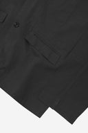 Close-up view of the cuff, jetted hip pocket and corozo buttons of the 3047 docklands blazer from Uskees. Also is a closer view of the texture of the black organic cotton twill . 