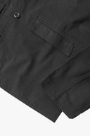 Close-up view of the cuff, jetted hip pocket and corozo buttons of the 3047 docklands blazer from Uskees. Also is a closer view of the texture of the charcoal-grey organic cotton twill . 