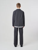 Back view of male model wearing the Uskees 3047 Docklands charcoal-grey blazer with view of back vent.