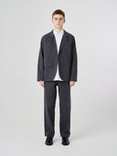 Full-length front view of male model wearing the Uskees 3047 Docklands charcoal-grey blazer unbuttoned, paired with matching Uskees pants.