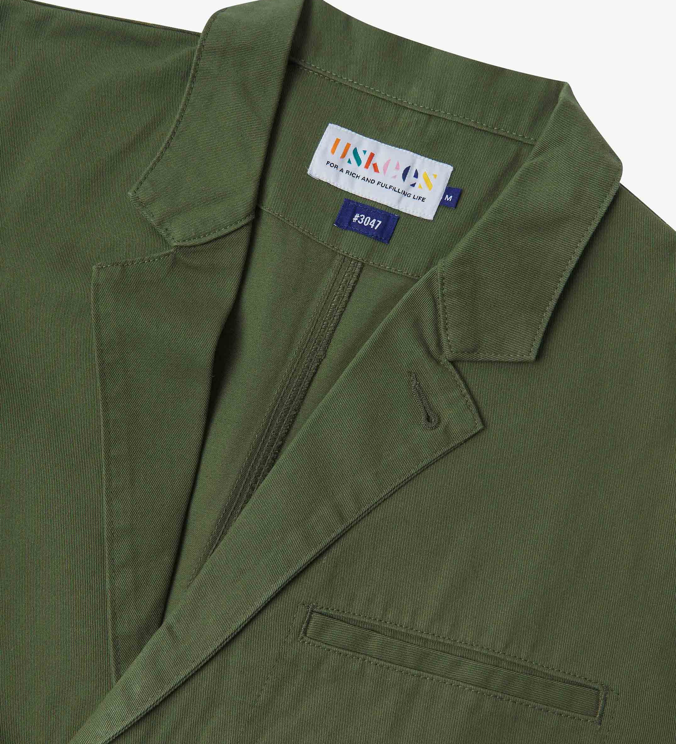 Close-up and angled front view of the 3047 docklands blazer showing the twill fabric texture, collar, lapel, Uskees branding label and jetted breast pocket.