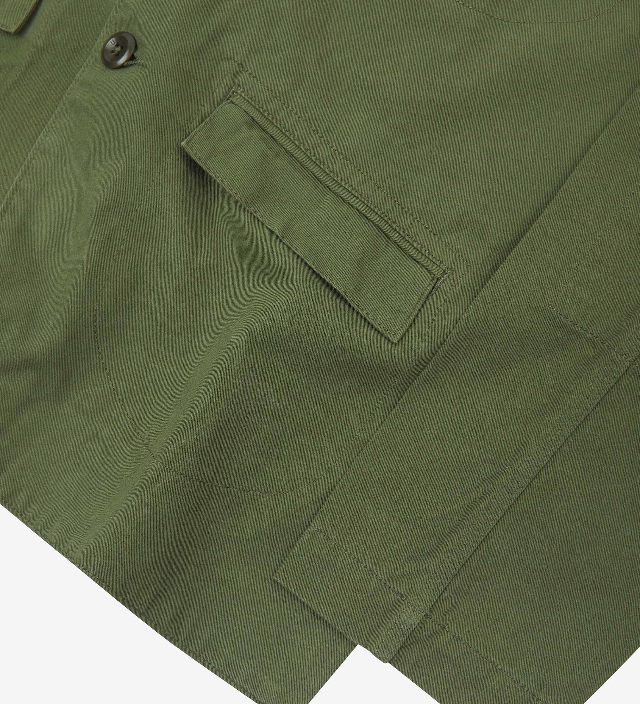 Close-up view of the cuff, jetted hip pocket and corozo buttons of the 3047 docklands blazer from Uskees. Also is a closer view of the texture of the coriander-green organic cotton twill. 