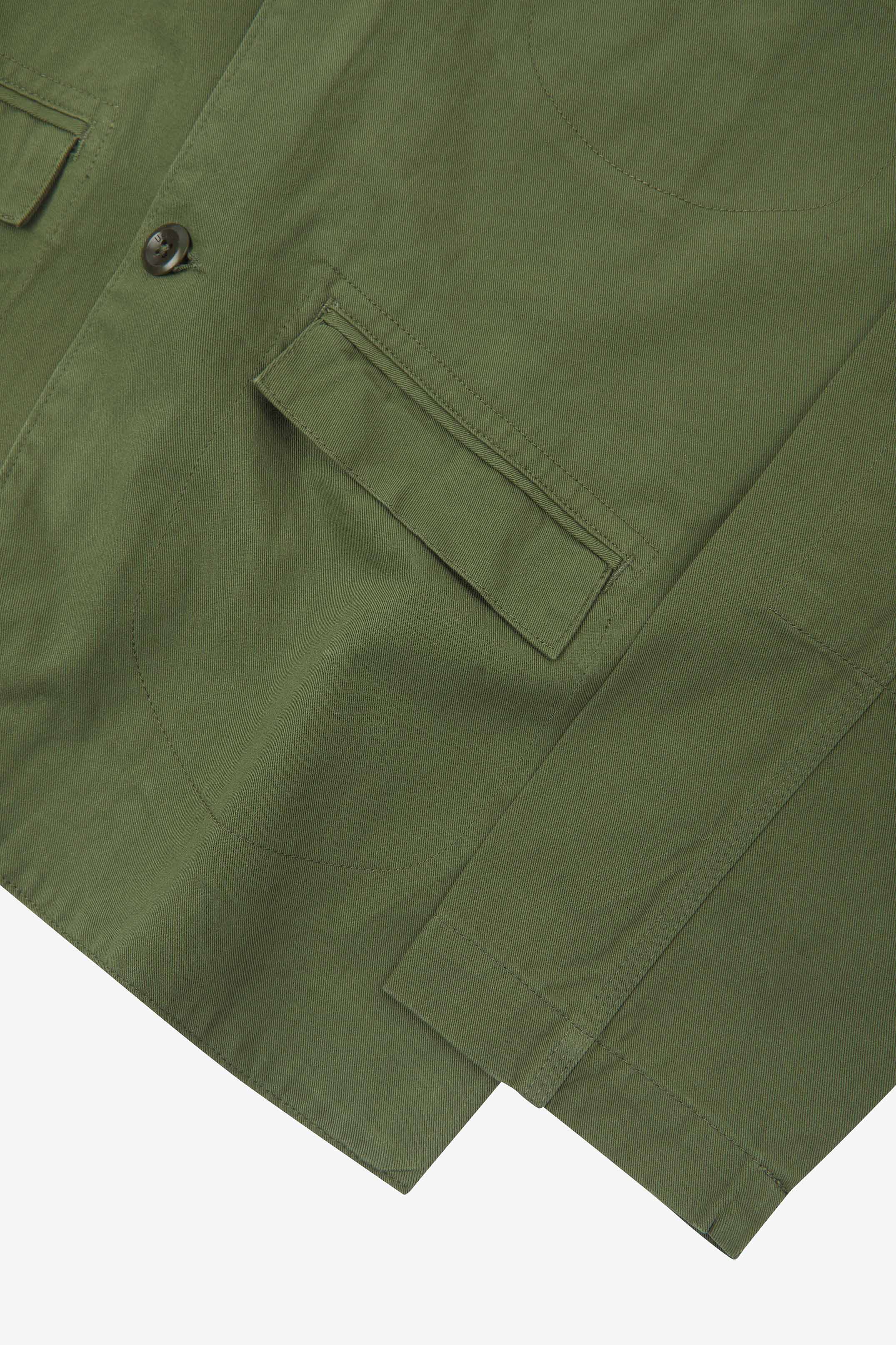 Close-up view of the cuff, jetted hip pocket and corozo buttons of the 3047 docklands blazer from Uskees. Also is a closer view of the texture of the coriander-green organic cotton twill. 