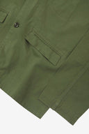 Close-up view of the cuff, jetted hip pocket and corozo buttons of the 3047 docklands blazer from Uskees. Also is a closer view of the texture of the coriander-green organic cotton twill. 