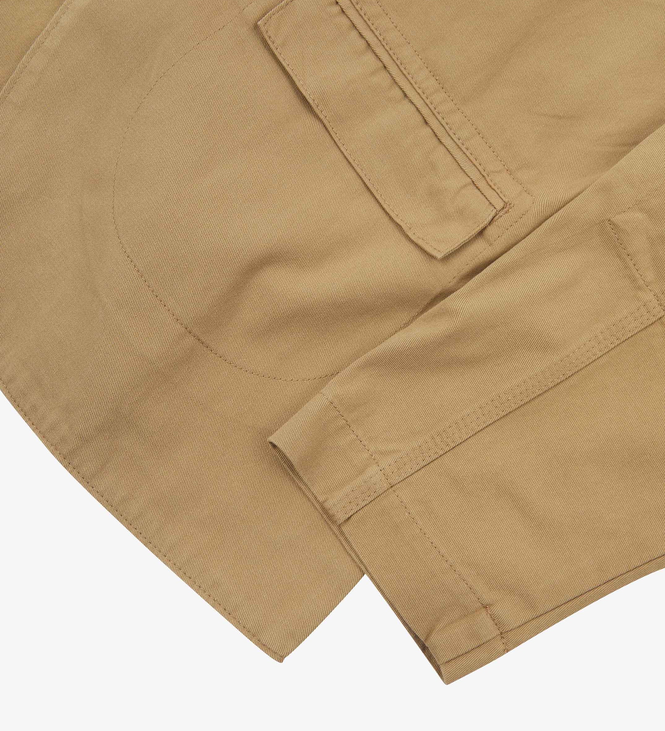 Close-up view of the cuff, jetted hip pocket and corozo buttons of the 3047 docklands blazer from Uskees. Also is a closer view of the texture of the khaki organic cotton twill . 