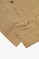 Close-up view of the cuff, jetted hip pocket and corozo buttons of the 3047 docklands blazer from Uskees. Also is a closer view of the texture of the khaki organic cotton twill . 