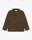  Front flat shot of an Uskees brown linen blazer for men showing the brand label and Corozo buttons.