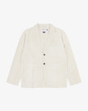 Front flat shot of an Uskees cream linen blazer for men showing the brand label and Corozo buttons.