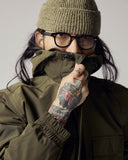 Model wearing Uskees army green Evo shell coat with focus on high funnel neck with integrated hood.
