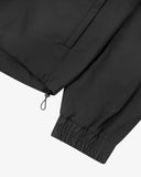 Close up view of Uskees charcoal-grey Evo shell coat with focus on elasticated cuff, waist toggle and welt pocket.