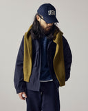 Model wearing Uskees midnight blue Evo shell coat paired with various Uskees garments in layers.
