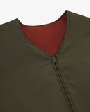Close up view of Uskees army green Evo liner jacket with focus on the neckline, orange-red lining and zip.
