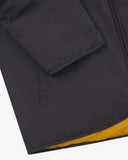 Close up view of Uskees charcoal-grey Evo liner jacket with focus on the left welt pocket, cuff and hemline.