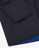 Close up view of Uskees midnight blue Evo liner jacket with focus on the left welt pocket, cuff and hemline.