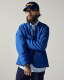 Front view of model wearing Uskees midnight blue Evo liner jacket. Reversed to show the bright blue lining as the outer shell.