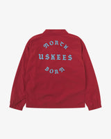 Back view flat shot of Uskees clay red coach jacket for men with focus on the the North Born Uskees slogan, straight-cut hem and elasticated cuffs.