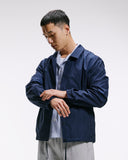 Top-half front view modelling Uskees 3052 navy blue coach jacket.