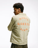 Top-half back view modelling Uskees 3052 pastel yellow check coach jacket with focus on the the North Born Uskees slogan.