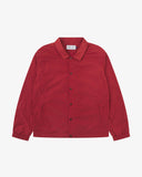 Front flat shot of Uskees bright red polyester coach's jacket  for men showing front poppers. Presented on a grey background.