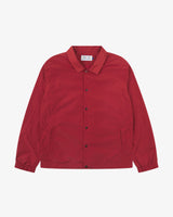 Front flat shot of Uskees bright red polyester coach's jacket  for men showing front poppers. Presented on a grey background.