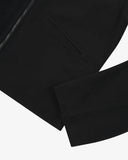 Close up shot of an Uskees zip up bomber jacket for men in black showing the front zip and sleeve detail.