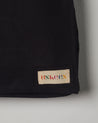 Close-up view of Uskees #4001 large tote bag in black showing the Uskees woven label.