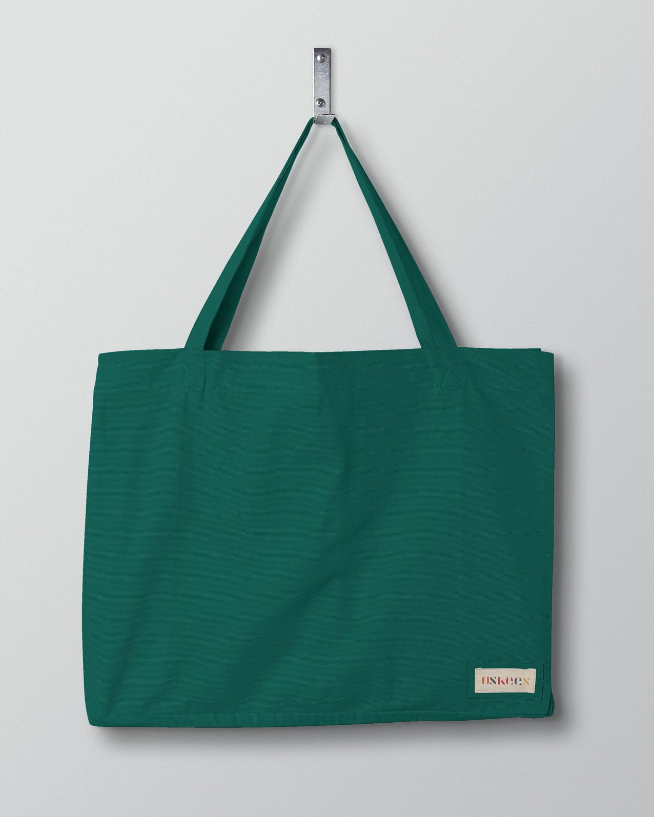Full front hanging shot of Uskees #4001 large foam-green tote bag, showing double handles and Uskees woven logo.