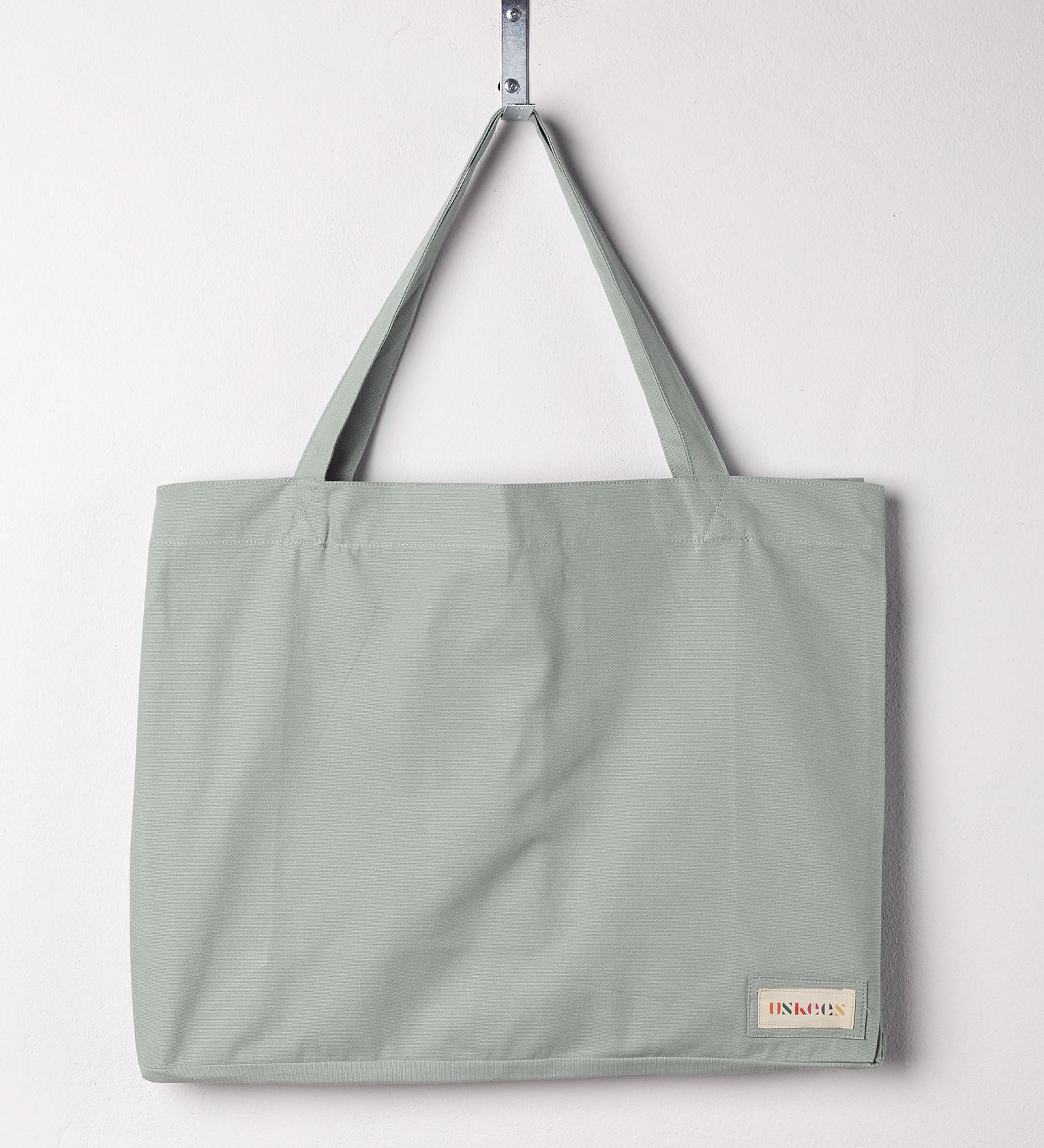 Full front hanging shot of Uskees #4001, large jade tote bag, showing double handles and Uskees woven logo.