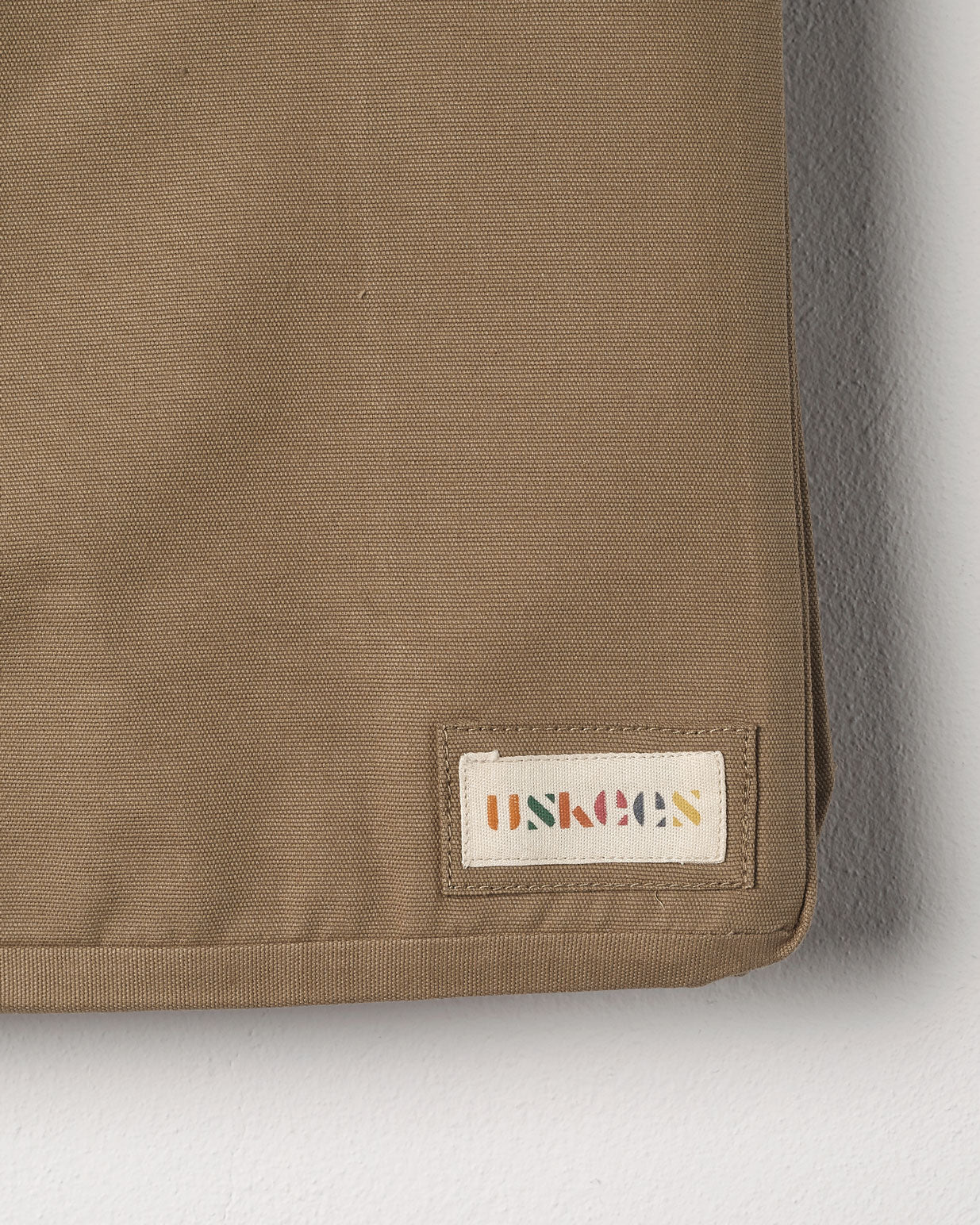 Close-up view of Uskees #4001 large tote bag in khaki showing the Uskees woven label.