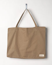 Hanging shot of Uskees #4001, large khaki tote bag, showing double handles and Uskees woven logo.
