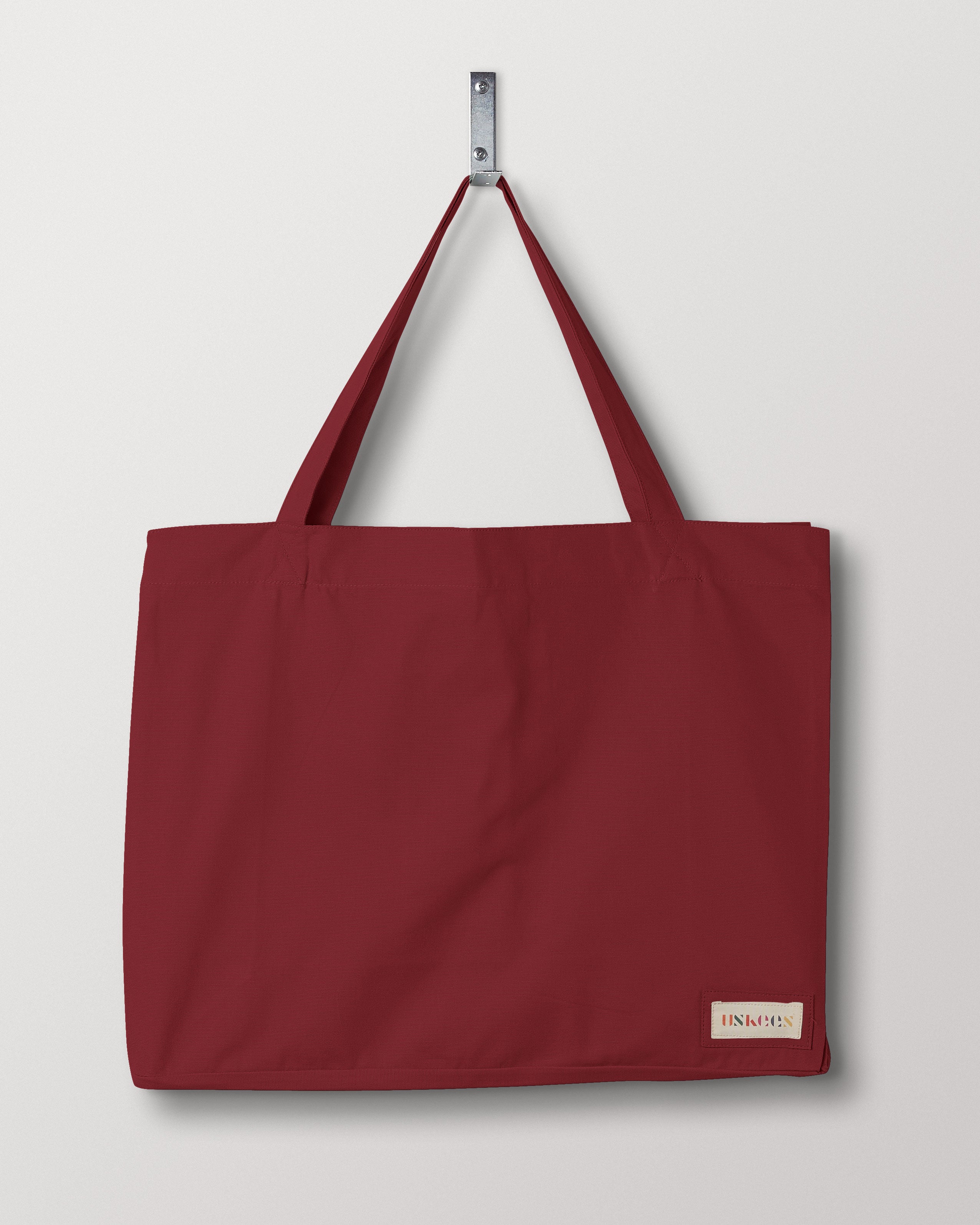 Full front flat shot of Uskees #4001, large 'merlot' coloured tote bag, showing double handles and Uskees woven logo.