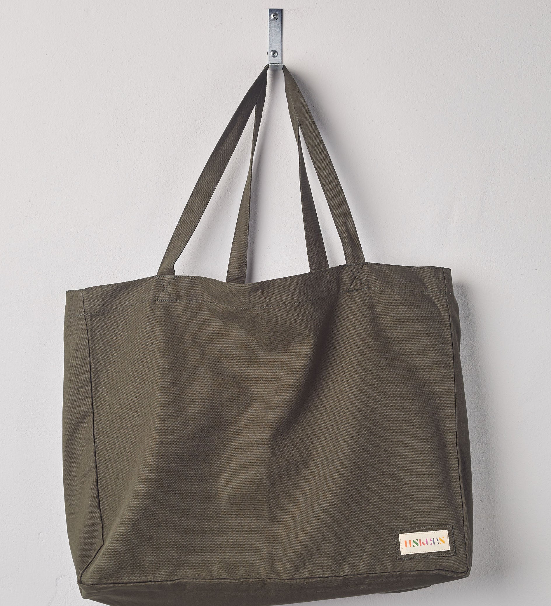 Full, flat view of Uskees #4001, large vine green tote bag, showing twin handles and Uskees woven logo. 