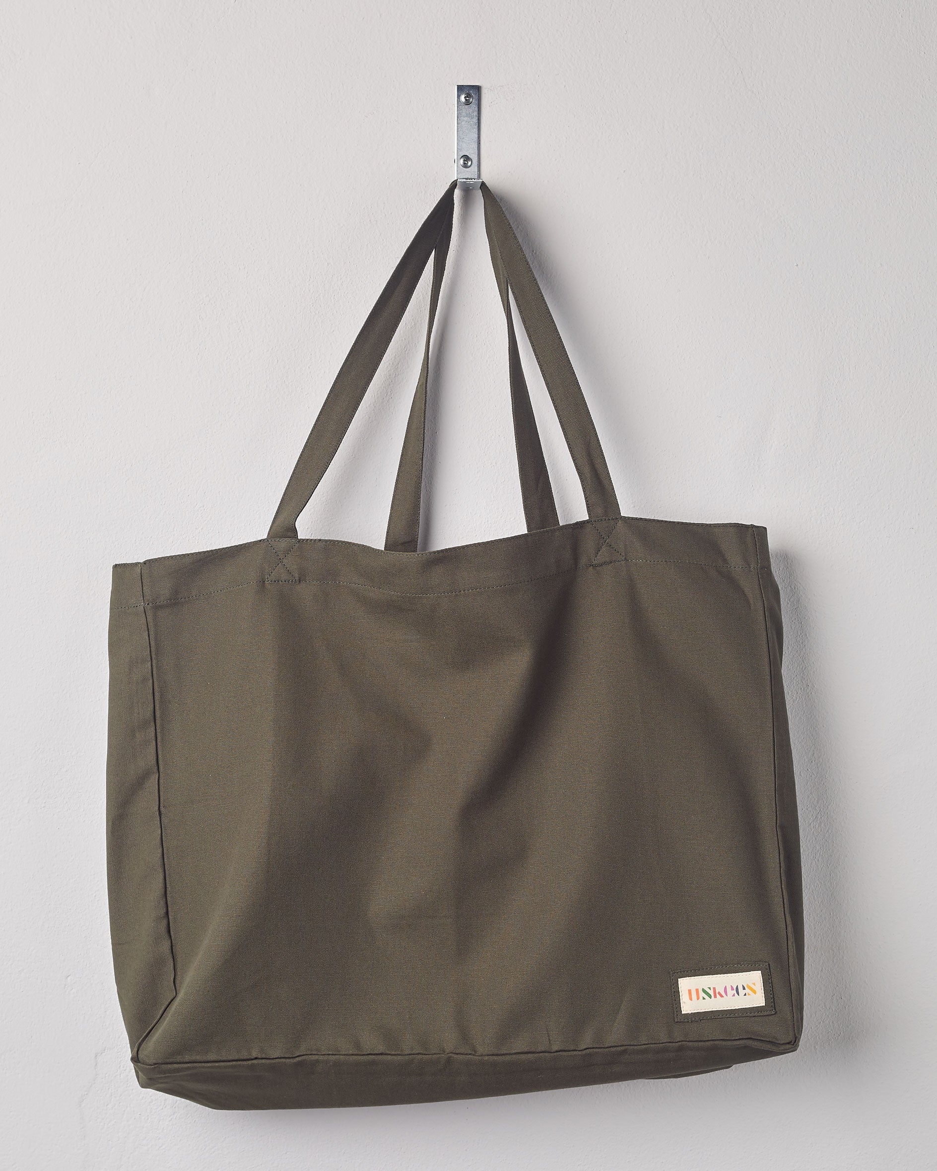 Full, flat view of Uskees #4001, large vine green tote bag, showing twin handles and Uskees woven logo. 