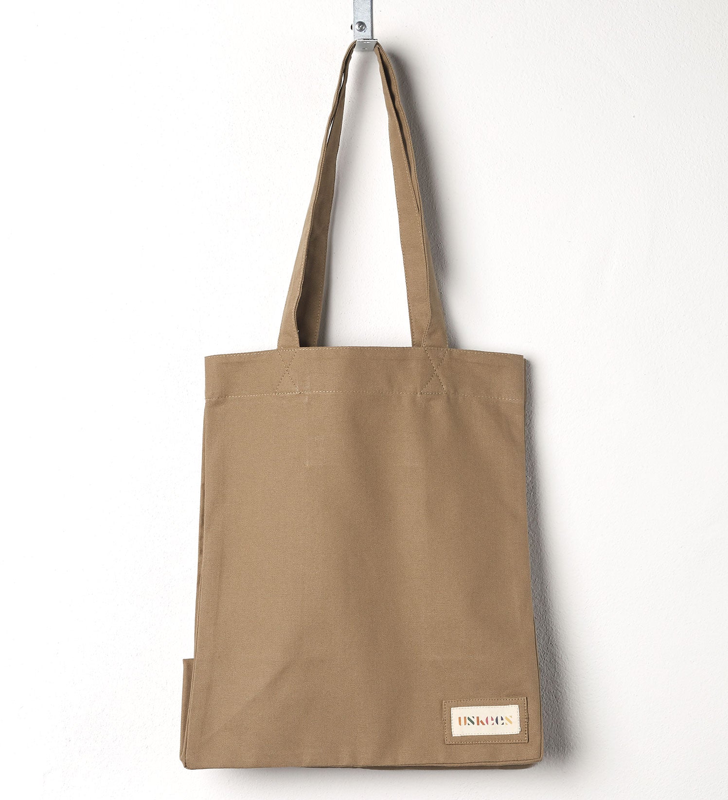 Full front hanging shot of Uskees #4002, small khaki tote bag, showing double handles.