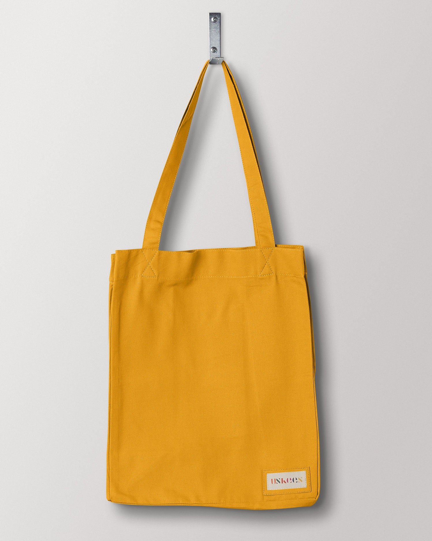 Full, flat view of Uskees #4002, small yellow tote bag. Clear view of double handles and Uskees woven logo.