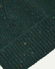 Close-up of the 'mallard green' donegal wool hat from Uskees, clearly showing the ribbing and multicoloured 'speckled' detail and texture of the natural Scottish merino wool.