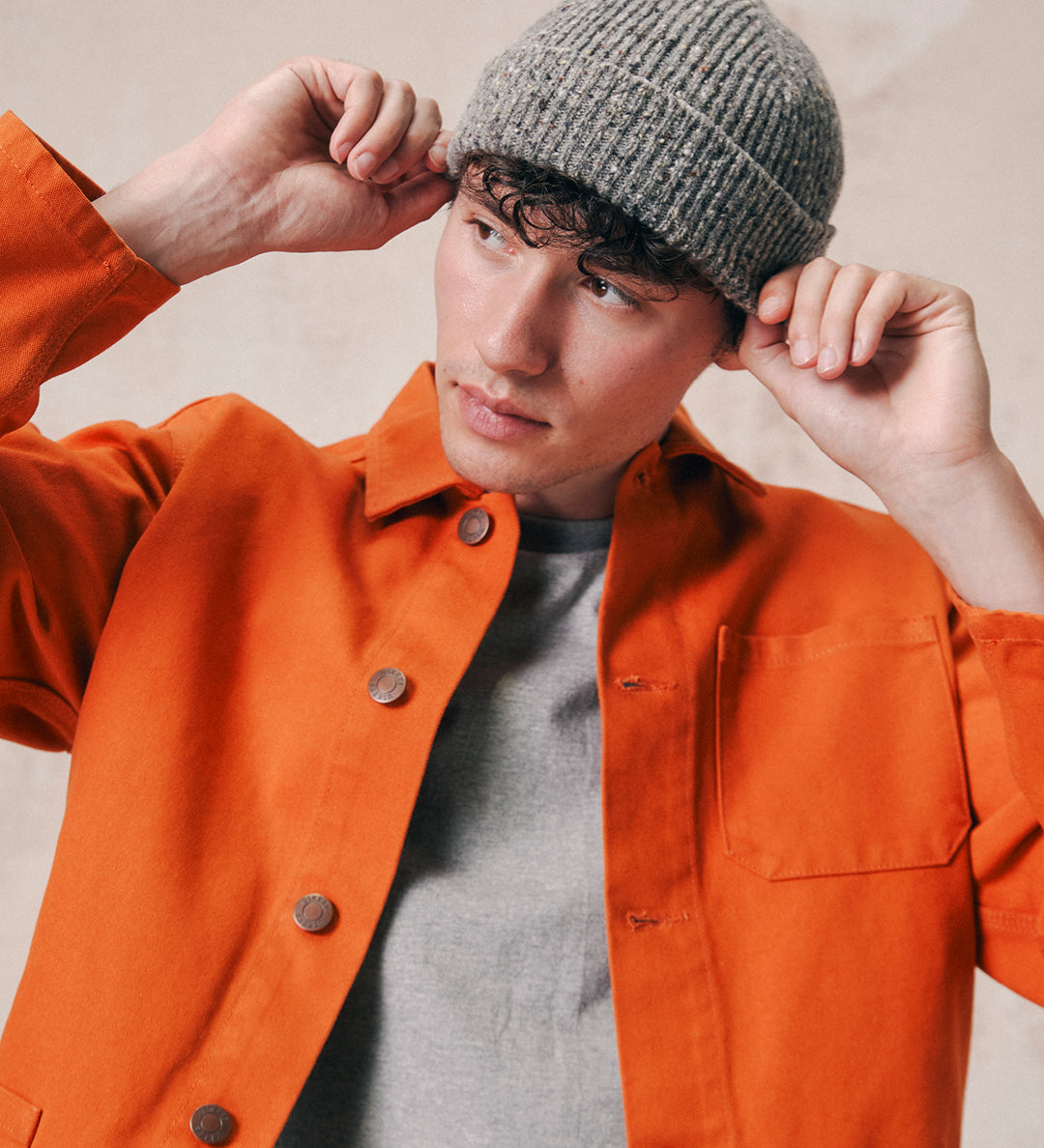 Male model wearing Uskees 4003 'silver-grey' speckled donegal wool hat. Paired with gold Uskees shirt.