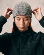 Female model wearing Uskees 4003 'silver-grey' speckled donegal wool hat. Paired with dark green corduroy Uskees shirt.