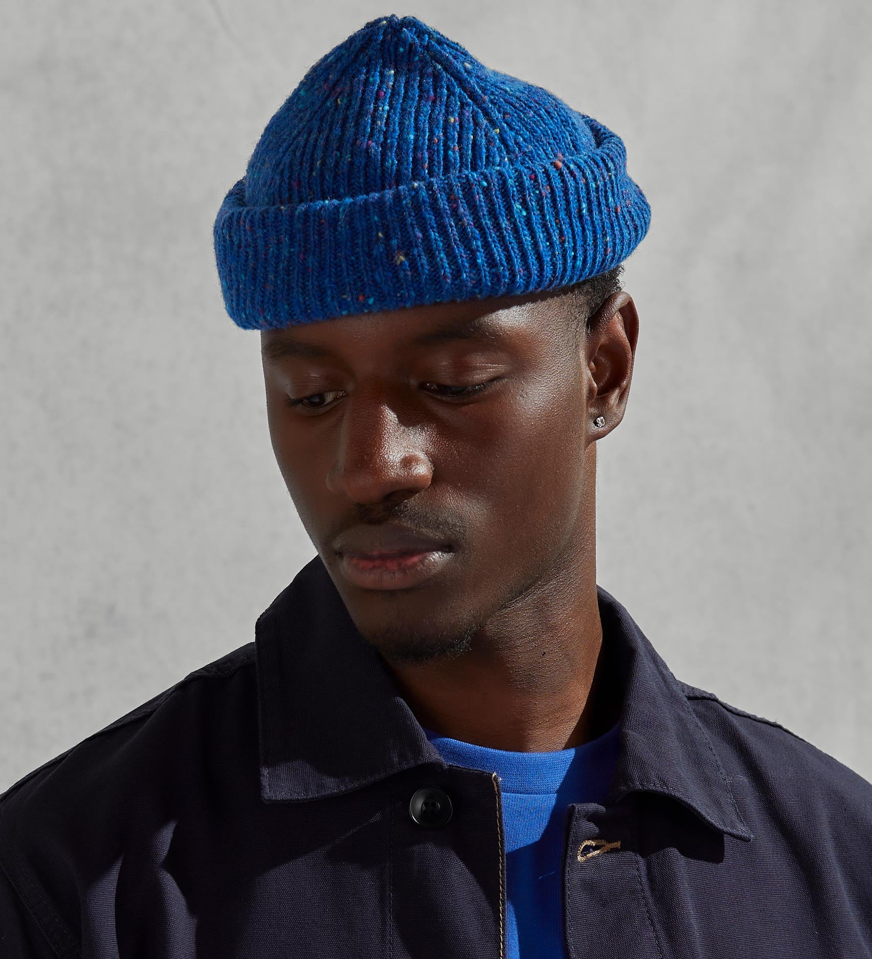 Model wearing Uskees 4003 'ultra blue' Donegal wool hat, paired with dark Uskees jacket.