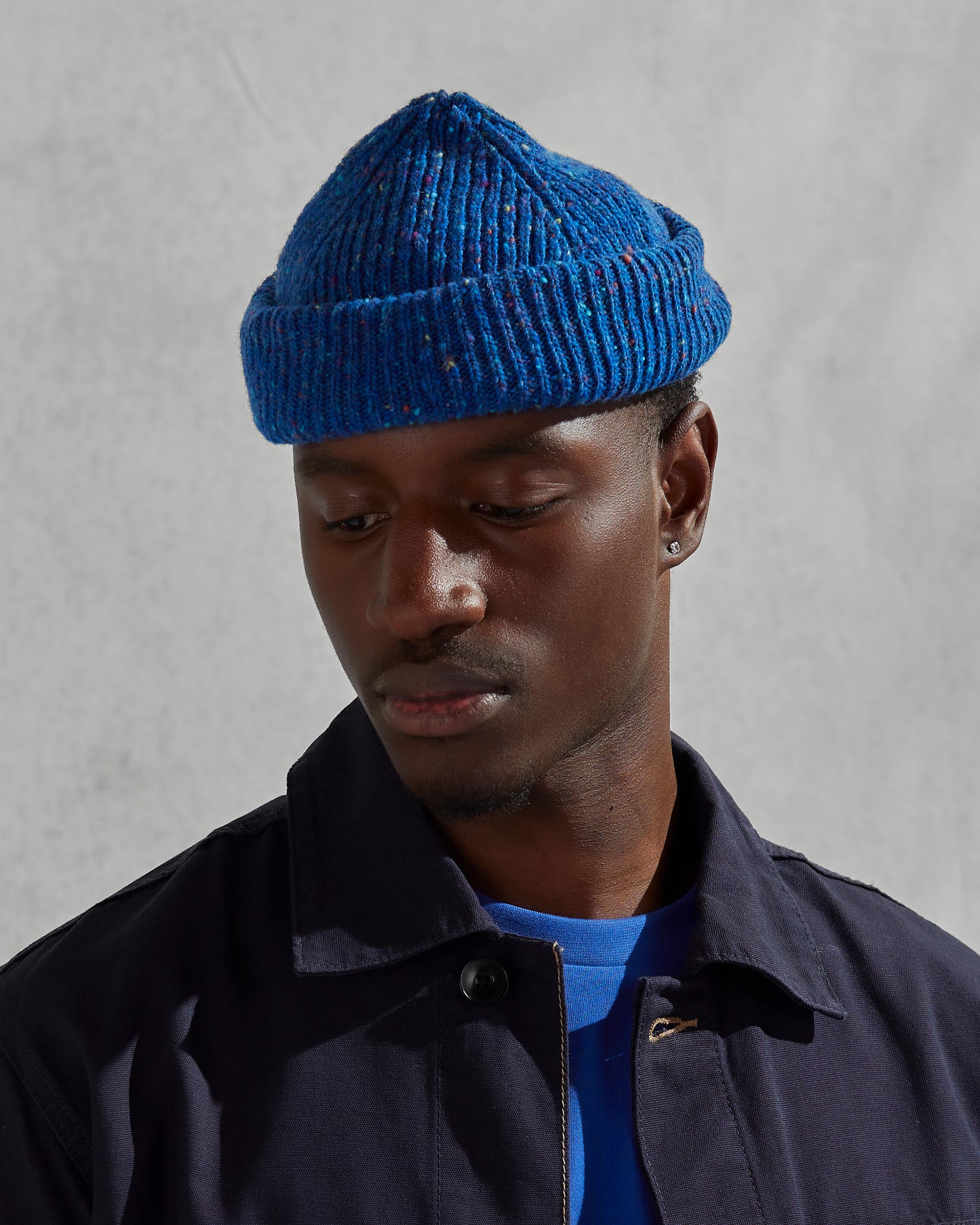 Model wearing Uskees 4003 'ultra blue' Donegal wool hat, paired with dark Uskees jacket.
