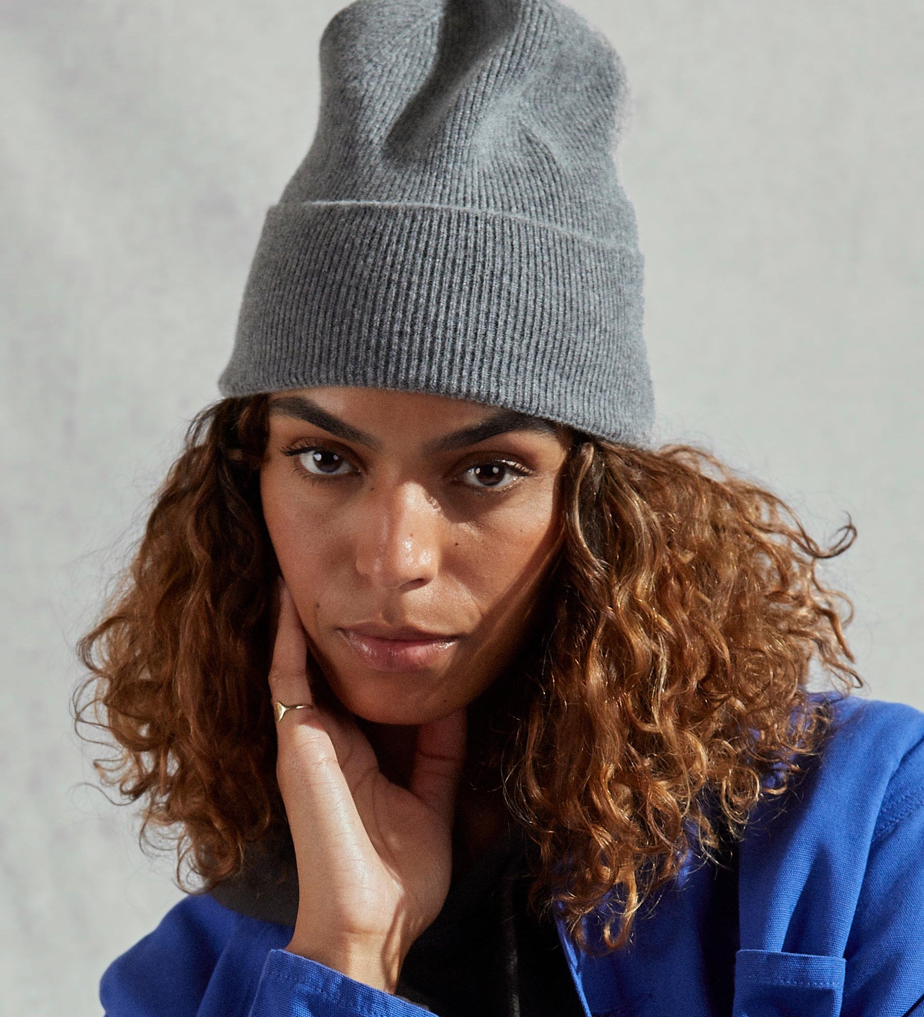 Woman wearing Uskees 4004 grey lambswool hat, paired with ultra blue Uskees jacket.
