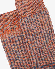 Close-up of pair of Uskees Men's socks in orange stripe pattern showing rib detail.