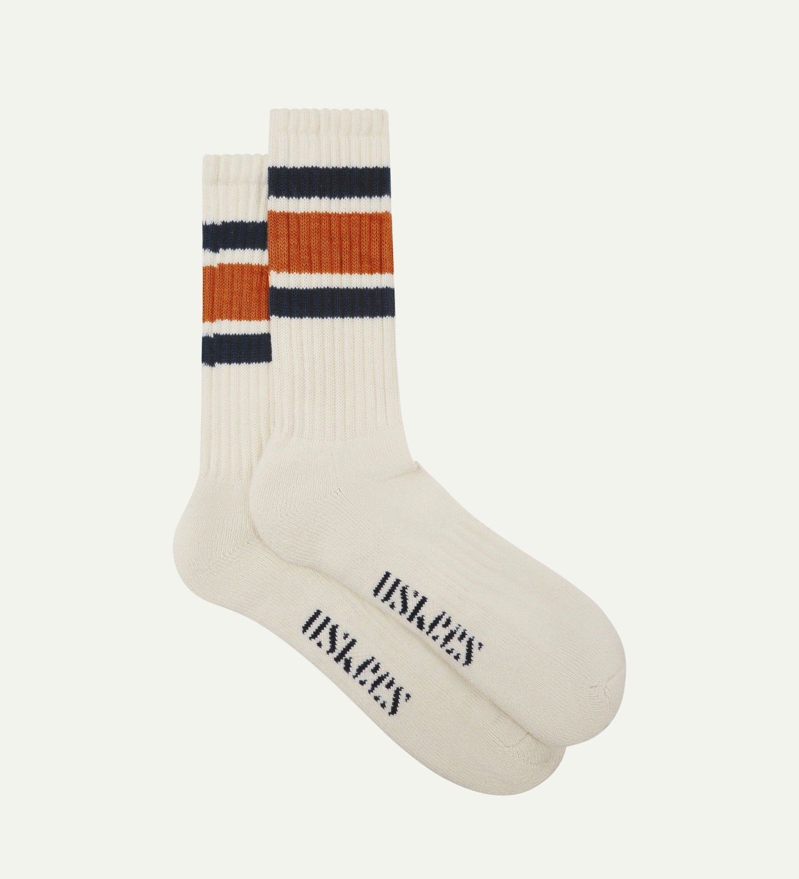 Flat view of a pair of Uskees 4011 gold-orange, organic cotton, college stripe socks, showing coloured bands and the Uskees branding at the base of each sock.