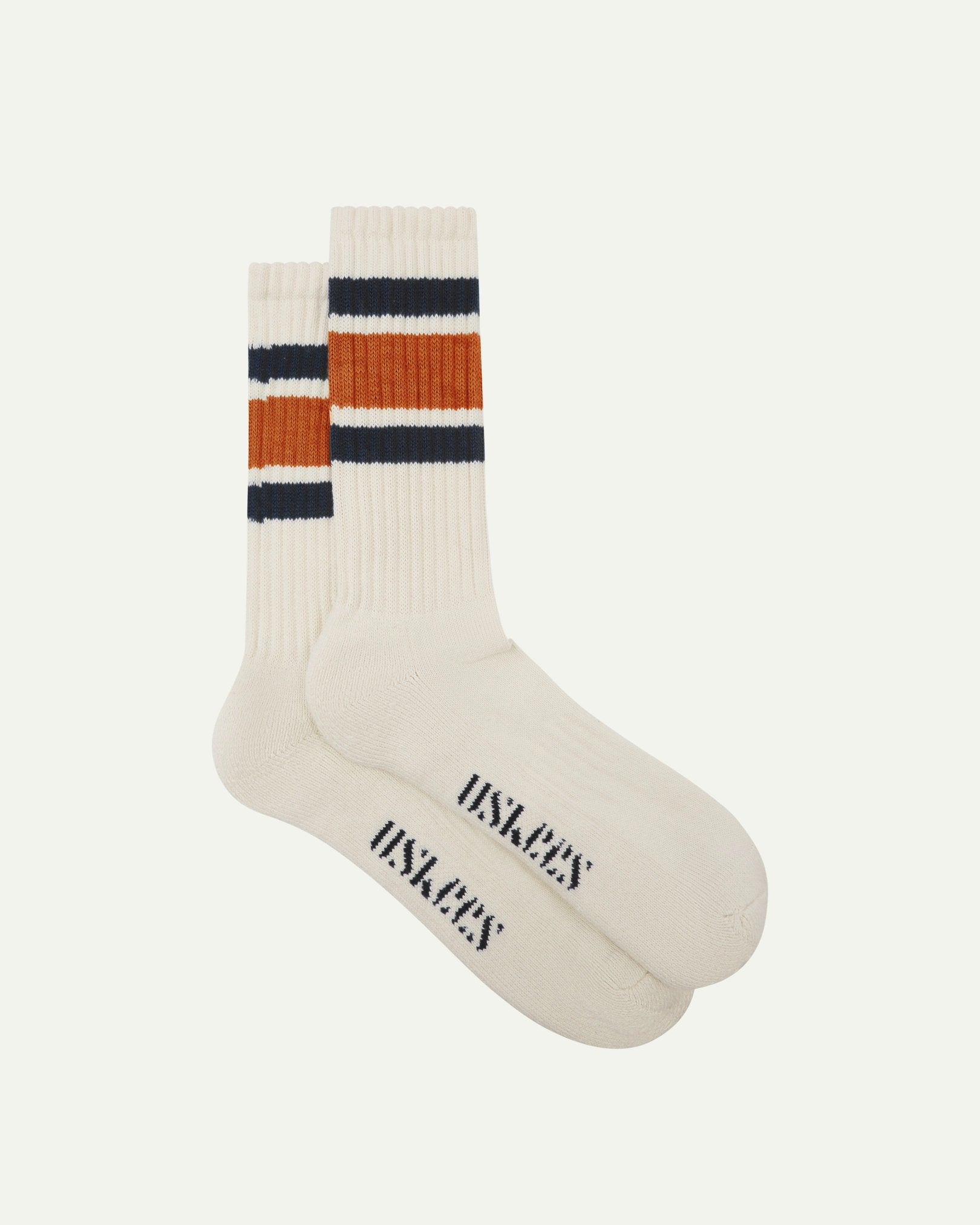 Flat view of a pair of Uskees 4011 gold-orange, organic cotton, college stripe socks, showing coloured bands and the Uskees branding at the base of each sock.