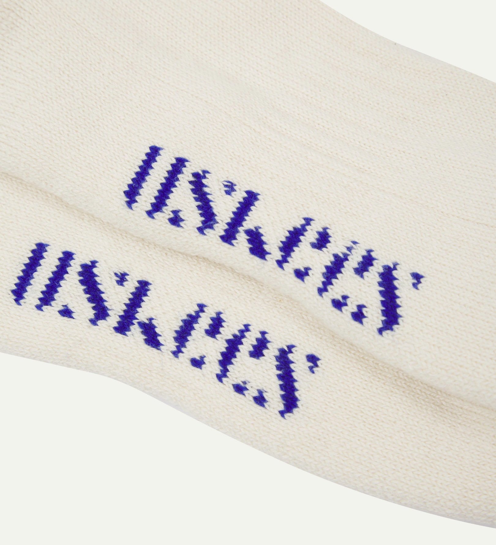 Close-up of a pair of Uskees 4011 khaki organic cotton sock college stripe socks, with a focus on the 'base' or 'foot' of the Uskees branding in ultra-blue.