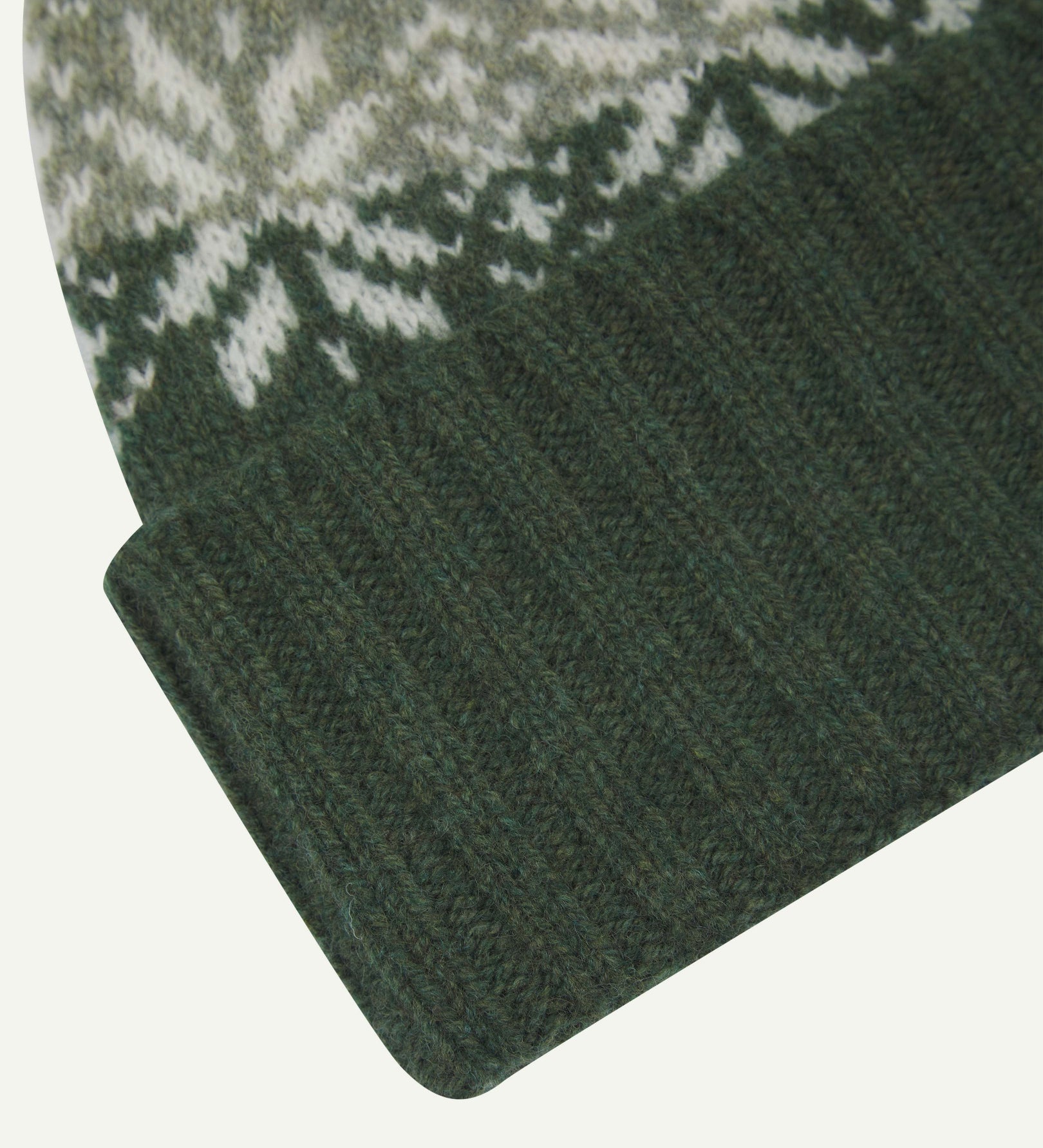 Close-up of the coriander snowflake hat from Uskees, clearly showing the ribbing of the adjustable cuff and texture of the natural Scottish lambswool.