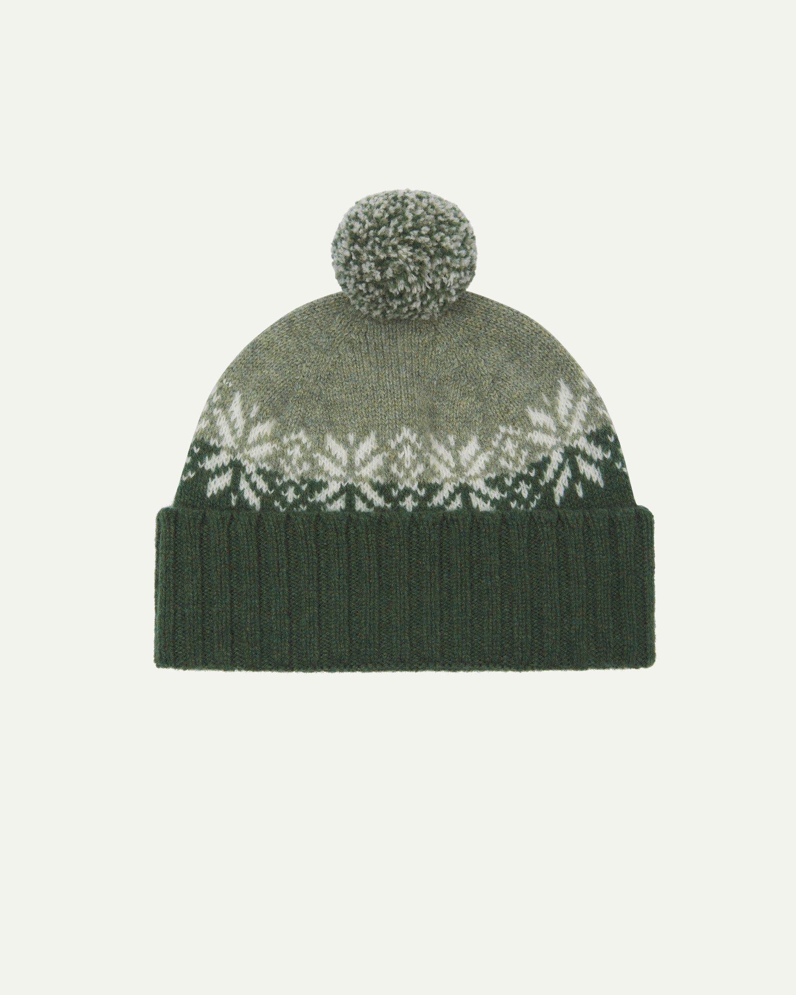 Front view of Uskees 4012 'coriander' lambswool snowflake hat, with a clear view of the coriander, pale green and white colourway, snowflake motif and bobble.