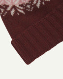 Close-up of the dusty pink snowflake hat from Uskees, clearly showing the ribbing of the adjustable cuff and texture of the natural Scottish lambswool.